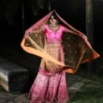 woman in purple and white floral dress standing on gray concrete floor